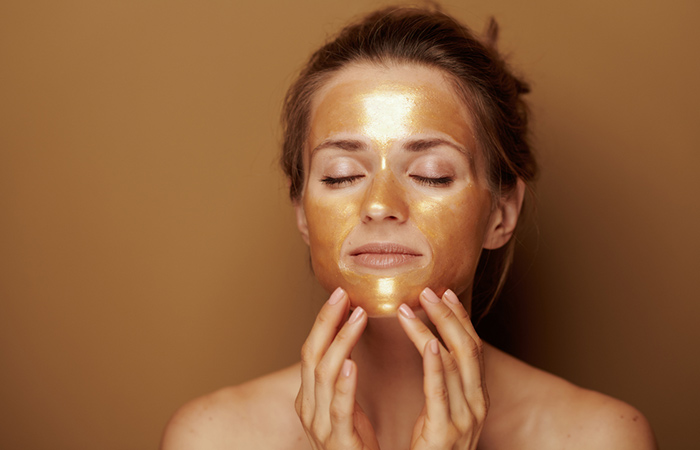 Woman with gold face pack