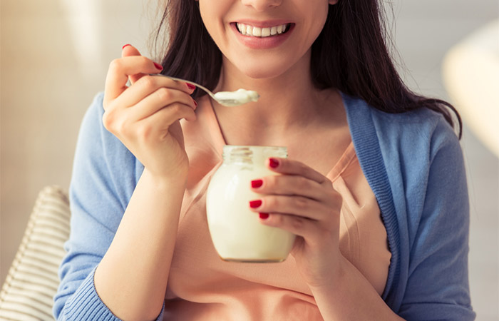 Woman having yogurt to follow glutamine rich diet plan 