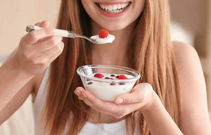 Woman eating yogurt to treat vaginal yeast infection