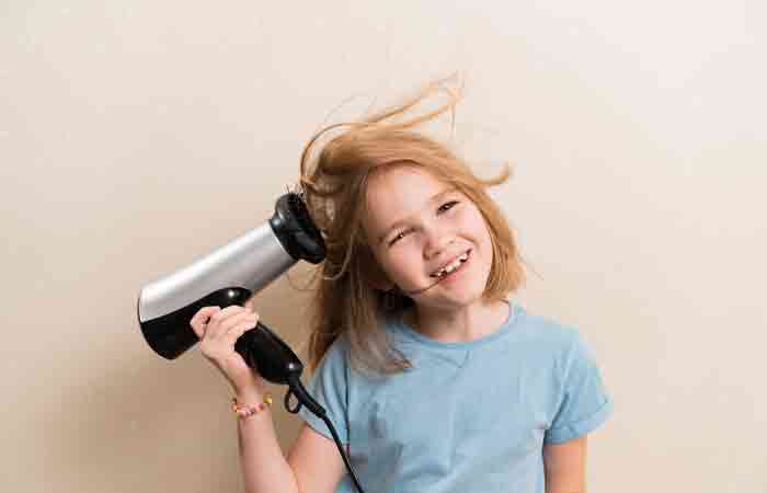 Girl blow drying her hair may experience hair loss