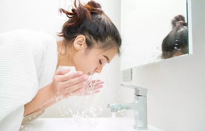 Woman cleaning her face for younger looking skin