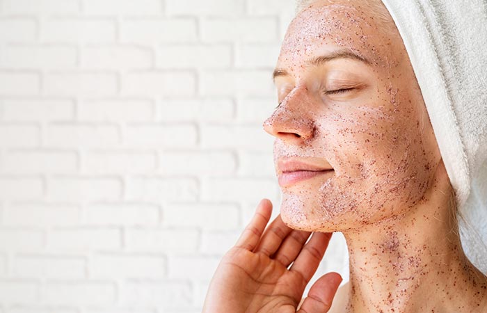 Woman exfoliating her face to look younger 