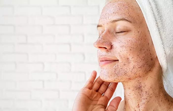 Woman exfoliating her face to look younger 
