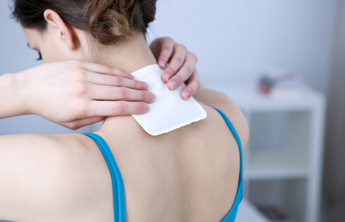 Woman uses arnica pain patch for relief.