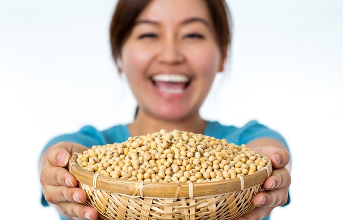 Woman holding a bowl of boiled soybeans.
