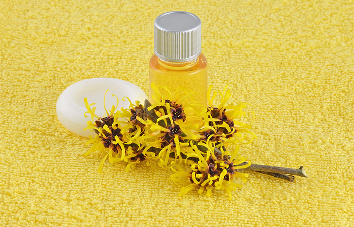 Container of witch hazel with cotton pad