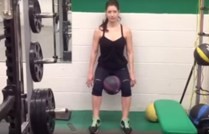 Wall sit with medicine ball