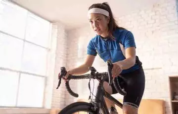 Woman cycling indoors as part of 1000-calorie workout