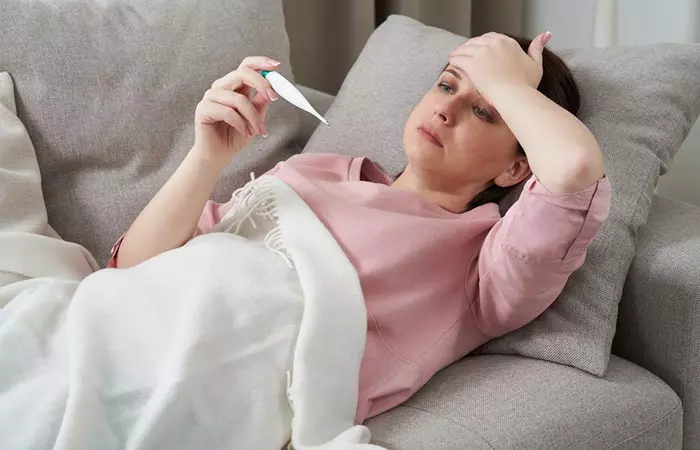 Woman dealing with a fever that may be treated with lily of the valley