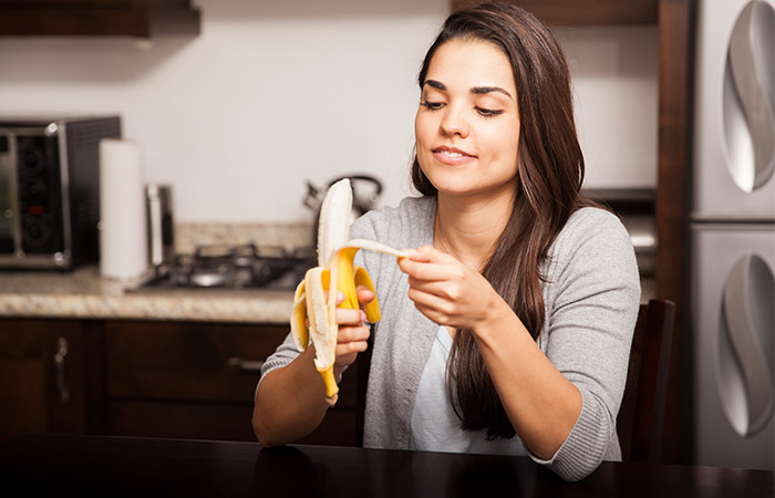 Woman peeling a ripe banana 