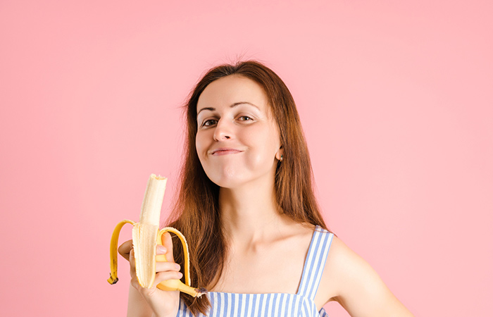 Woman eating banana to improve digestion