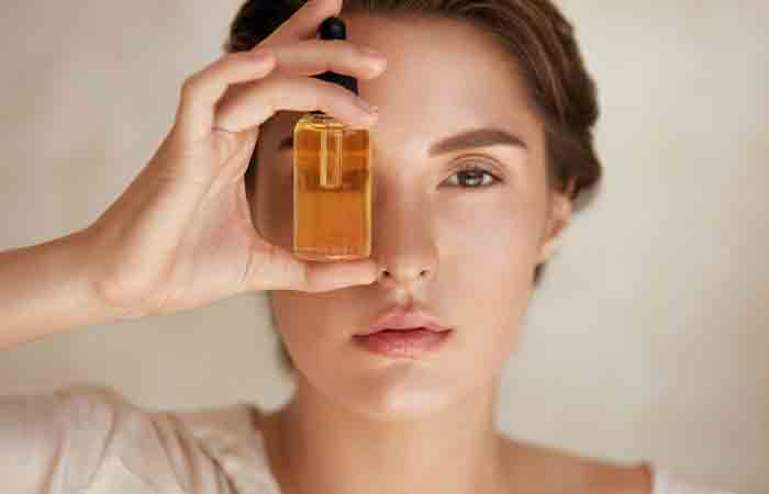 Woman holding a bottle of essential oil for styes