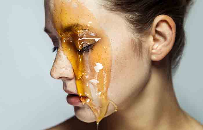 Woman with honey dripping on her face