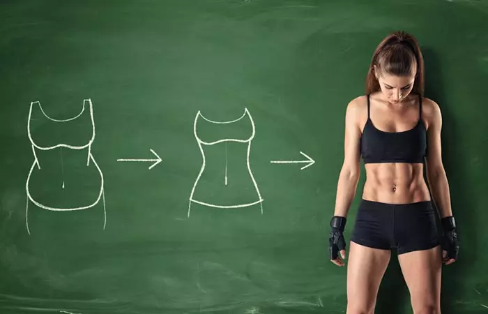 Woman looks at her toned abdominal muscles