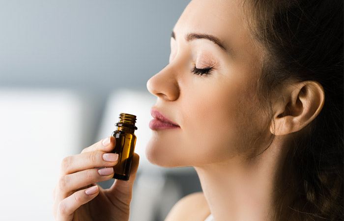 Woman smelling chamomile oil for aromatherapy