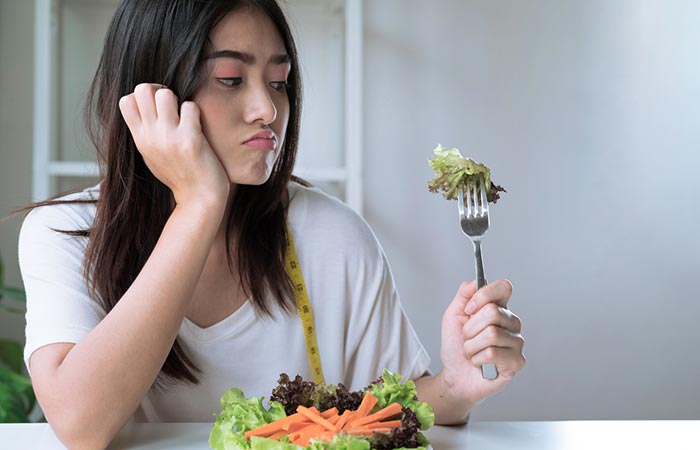 Woman frowns at her low calorie food as it is not enough to support her active lifestyle