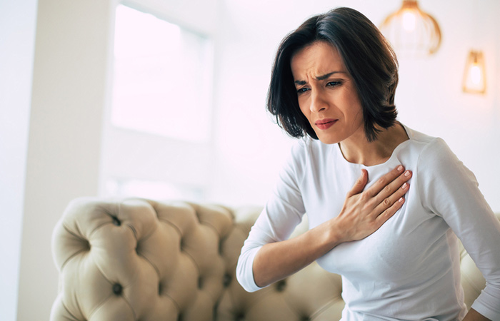 Woman experiencing chest pain as a side effect of consuming cilantro