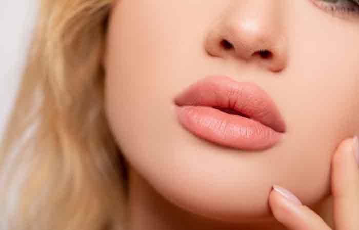 A woman flaunting her pucker-up lips with a lovely shade of pink lipstick