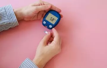 Woman with glucometer doing blood sugar test
