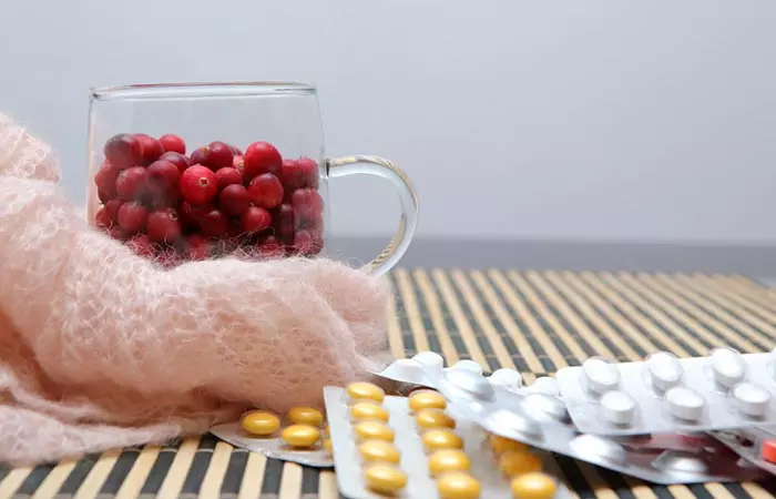 Tablet strips and cranberries in a glass