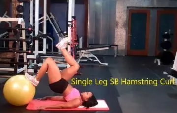 Single leg stability ball hamstring curl bridge exercise