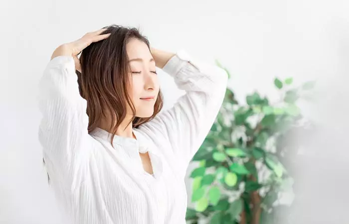 Woman massaging scalp with pomace olive oil