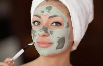 Woman using clay mask for blackheads on nose
