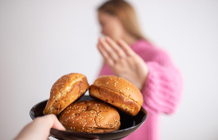 Woman saying no to buns with sesame seeds to prevent sesame allergy