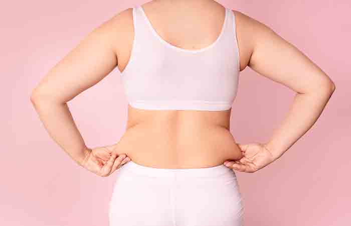 Woman pinches fat on the side of her waist
