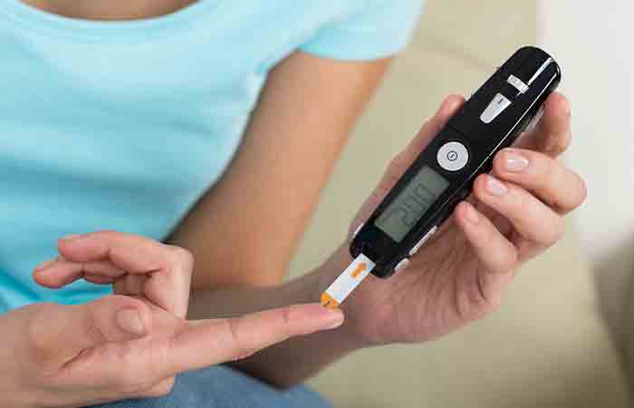 Woman using a glucometer to check her high blood sugar level due to a side effect of having honey