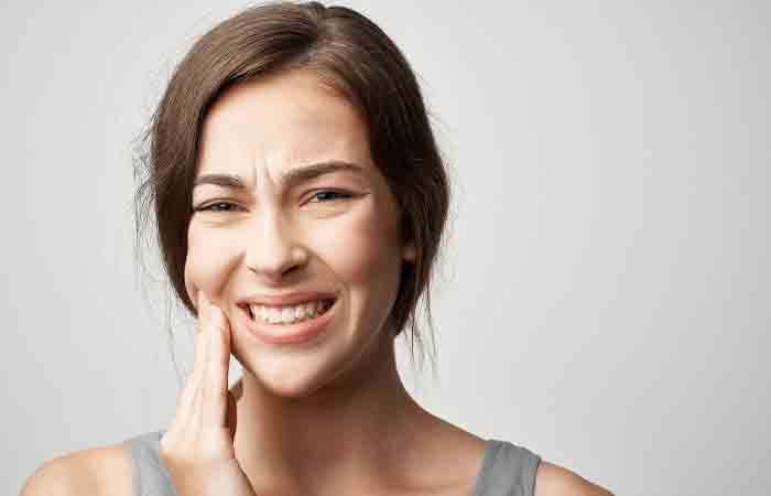 Woman experiencing tooth decay as a side effect of having honey