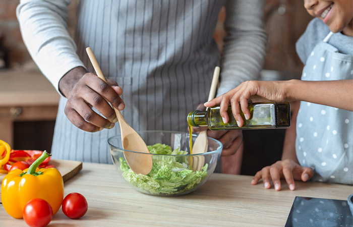 Man and woman using olive oil as salad dressing because it is rich in minerals