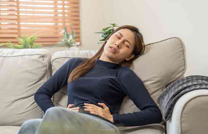 Woman holding her belly due to stomach ulcers as a side effect of peppermint tea