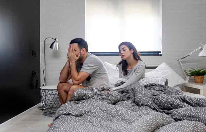 Wife tries to console disturbed husband in the bedroom