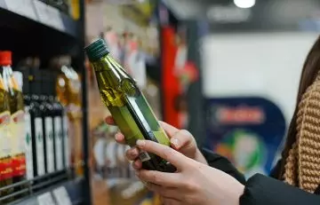 Woman choosing olive oil for consumption because it is healthy