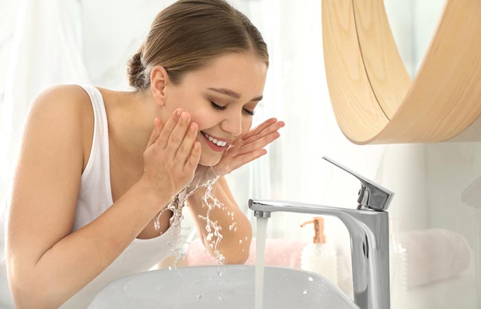 Woman washing her face to get rid of blackheads on nose
