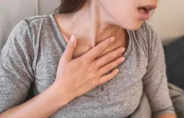 Close up of a woman experiencing difficulty in breathing as one of the symptoms of anaphylaxis