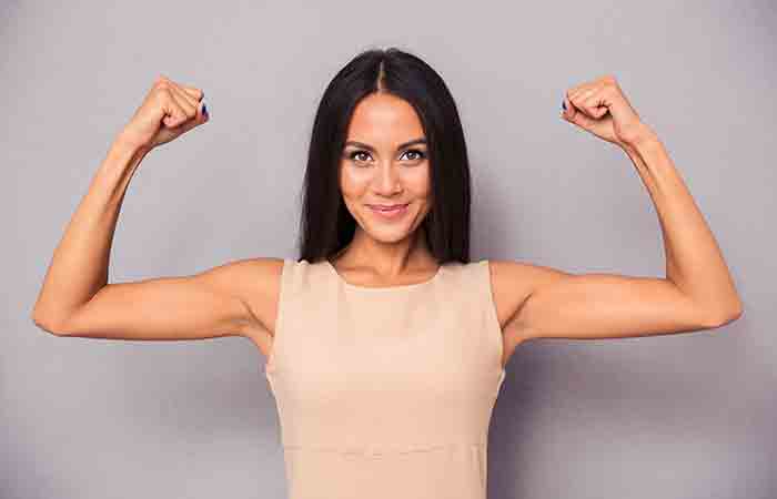 Woman flexing her arms after a butterfly chest workout 