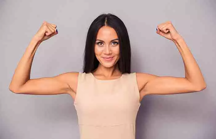 Woman flexing her arms after a butterfly chest workout 