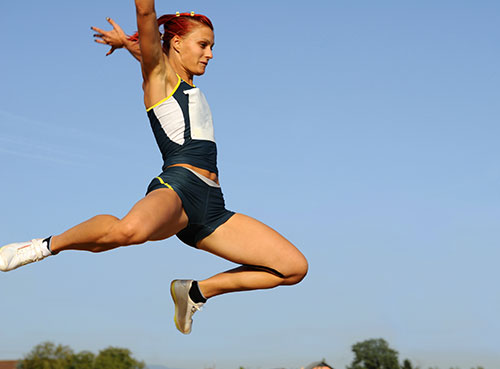 A woman doing a broad jumps exercise
