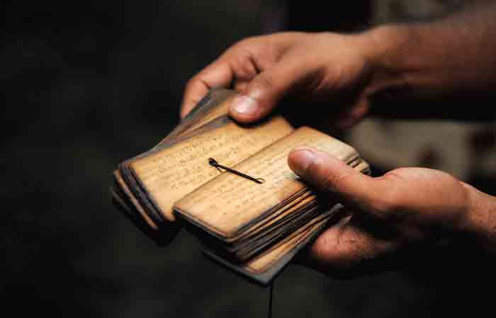 Person holding ancient mantra texts