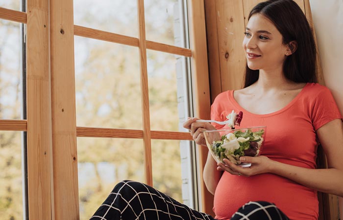 Pregnant woman enjoying a salad without mushroom