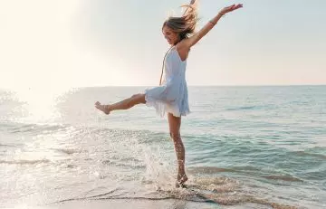 A woman near the sea feeling energetic and filled with joy and vitality