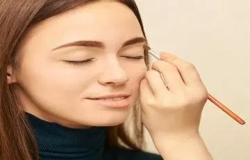 Woman applying primer on her eyes