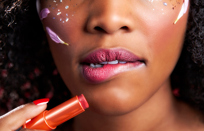 Close up of a woman with dark skin with pink lipstick