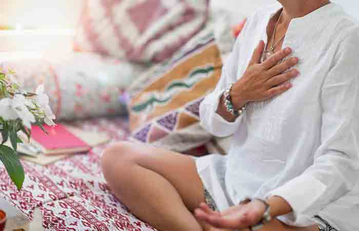 Woman activating heart chakra through pranic healing meditation