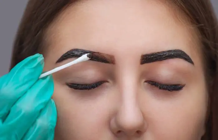  A woman coloring her eyebrows