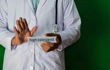 High cholestrol written on paper held by doctor