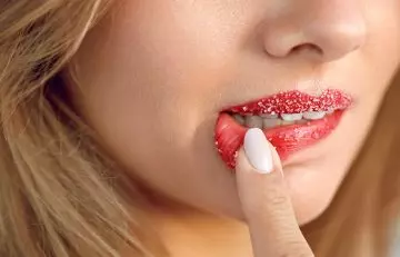 A woman exfoliating her red lips