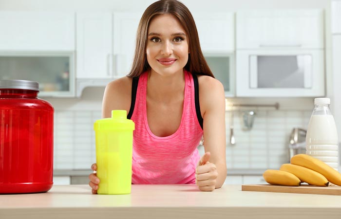 Fit woman consuming a healthy shake made of banana and milk